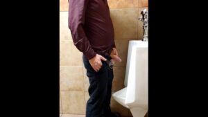 Watch – Ginger business man peeing at urinal